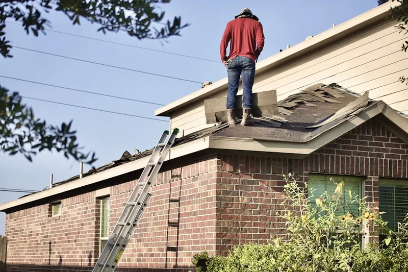 Professional roofer working on a residential roof in East Farmington Heights